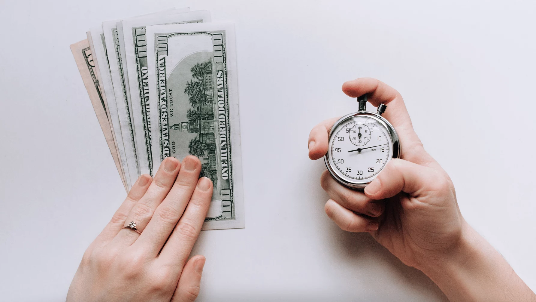 "A hand holding cash and another holding a stopwatch, showing time and money."
