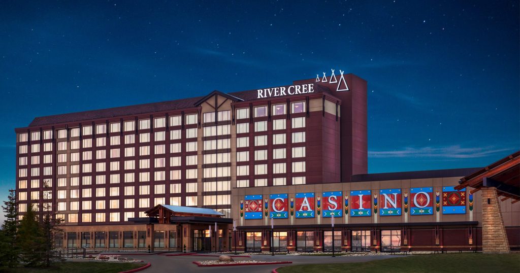 "River Cree Resort and Casino, Alberta: Nighttime view of the luxurious hotel and casino illuminated against a starry sky, showcasing its vibrant signage and elegant architecture."