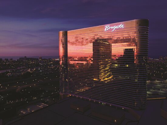 "Nighttime view of the Borgata Hotel Casino & Spa in Atlantic City, New Jersey, showcasing its reflective golden facade."