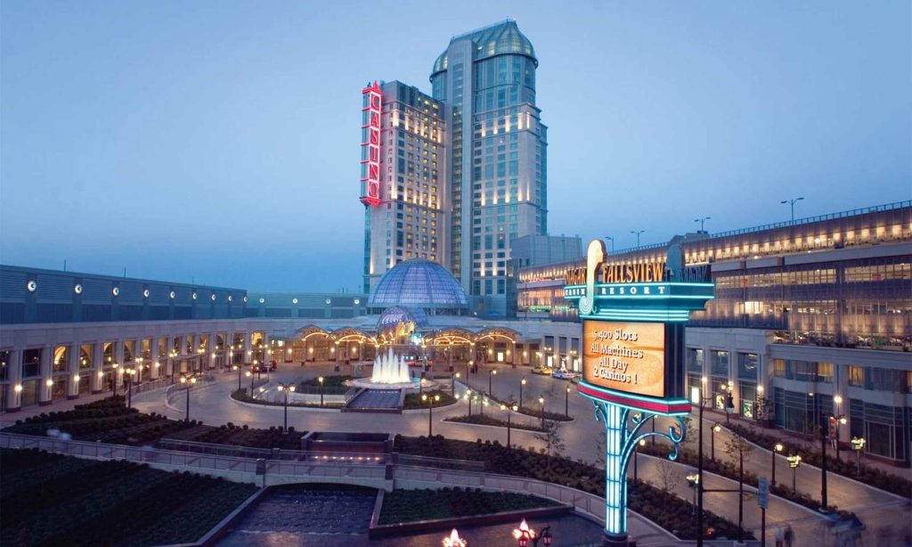 "Fallsview Casino Resort, ON: A grand casino with glowing signage, a central fountain, and elegant landscaping."