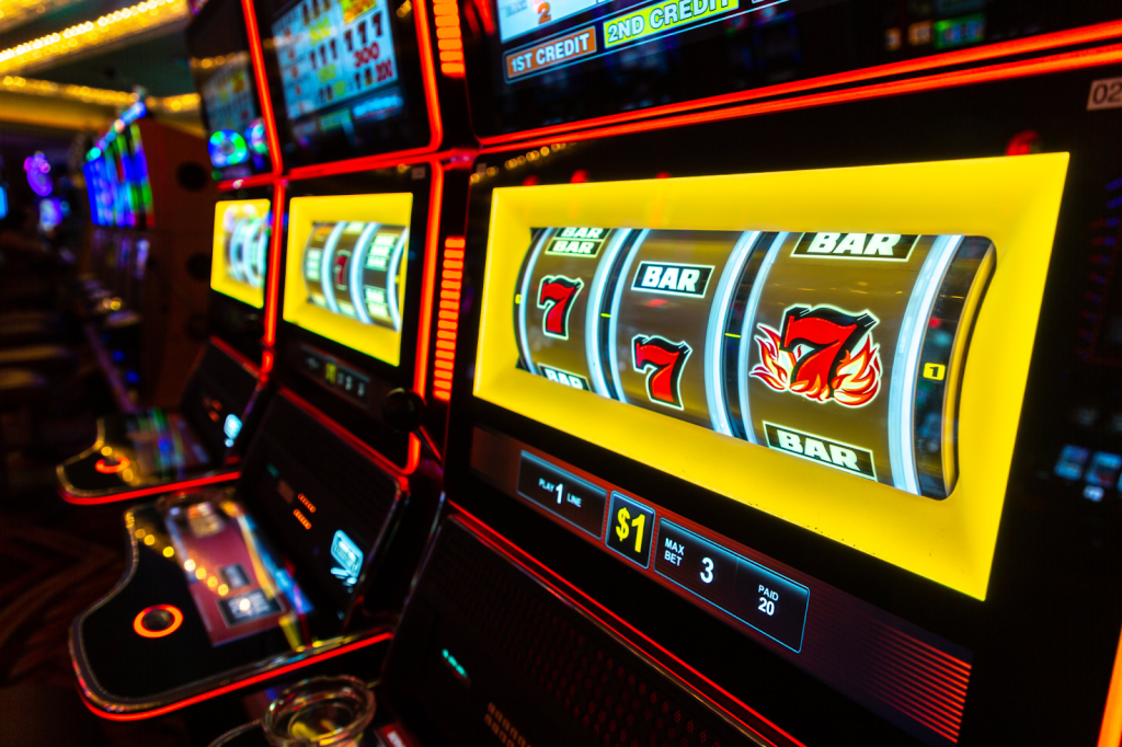 Close-up of a brightly lit slot machine with symbols like 7s and BARs, set in a vibrant casino atmosphere.