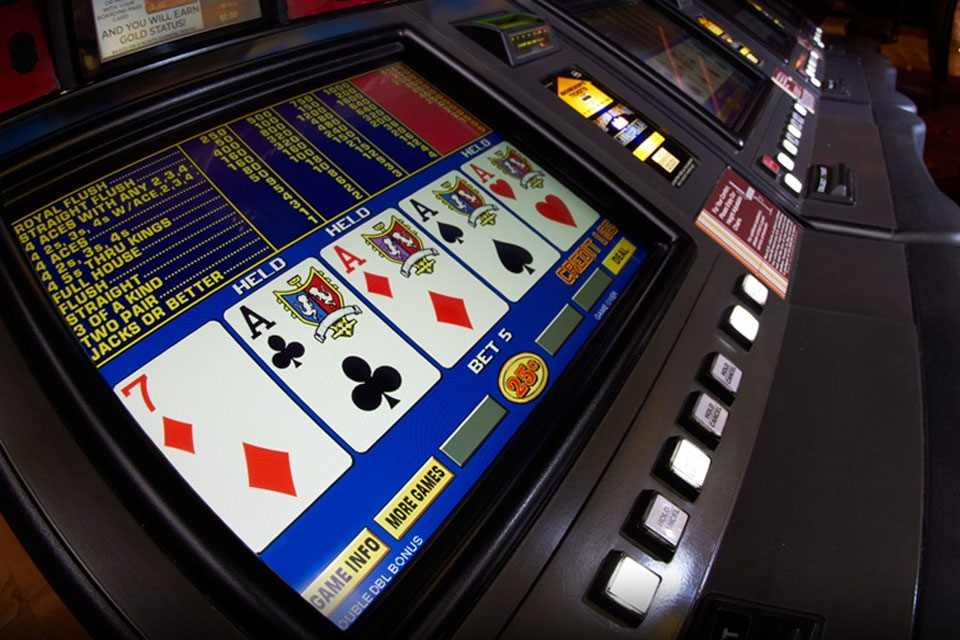 A row of video poker machines in casino displaying a winning hand of four aces, suitable for beginners due to simple gameplay.